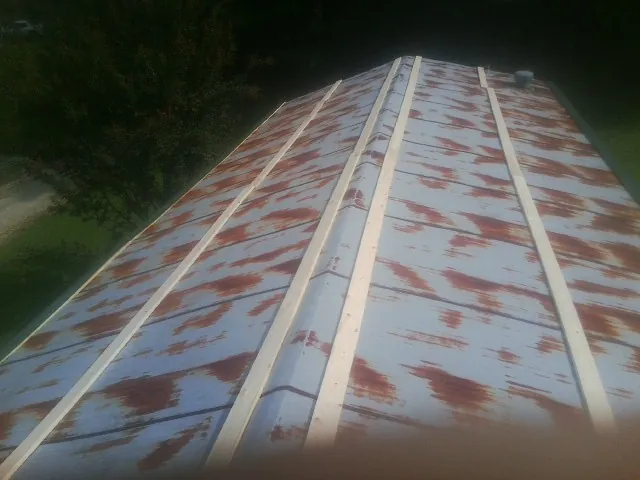 Rusted metal roof panels with new wood purlins before replacement — Storm Damage Roof Repair in Polo by Roofing Brothers