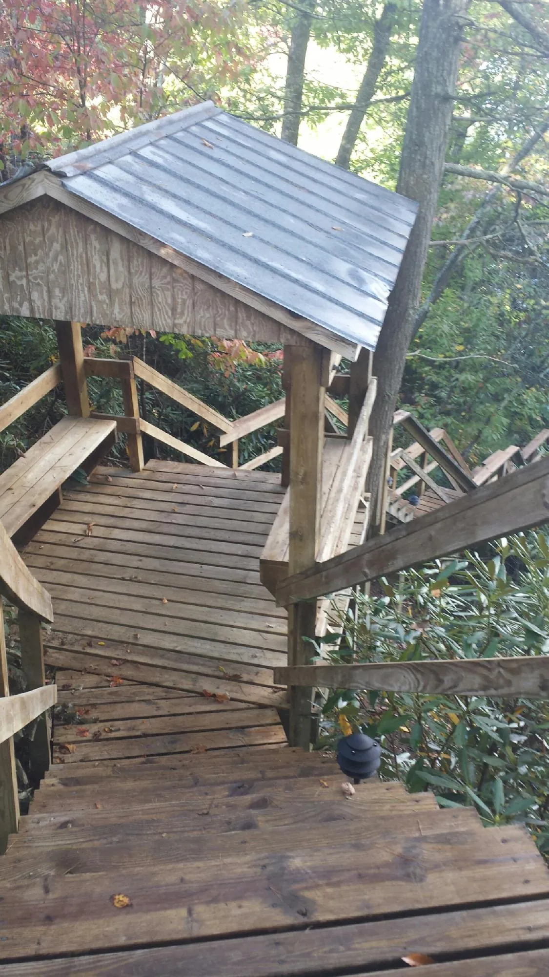 Metal roofed shelter over wooden steps on a wooded walkway — Skylight Repair & Installation work by our crew in Polo
