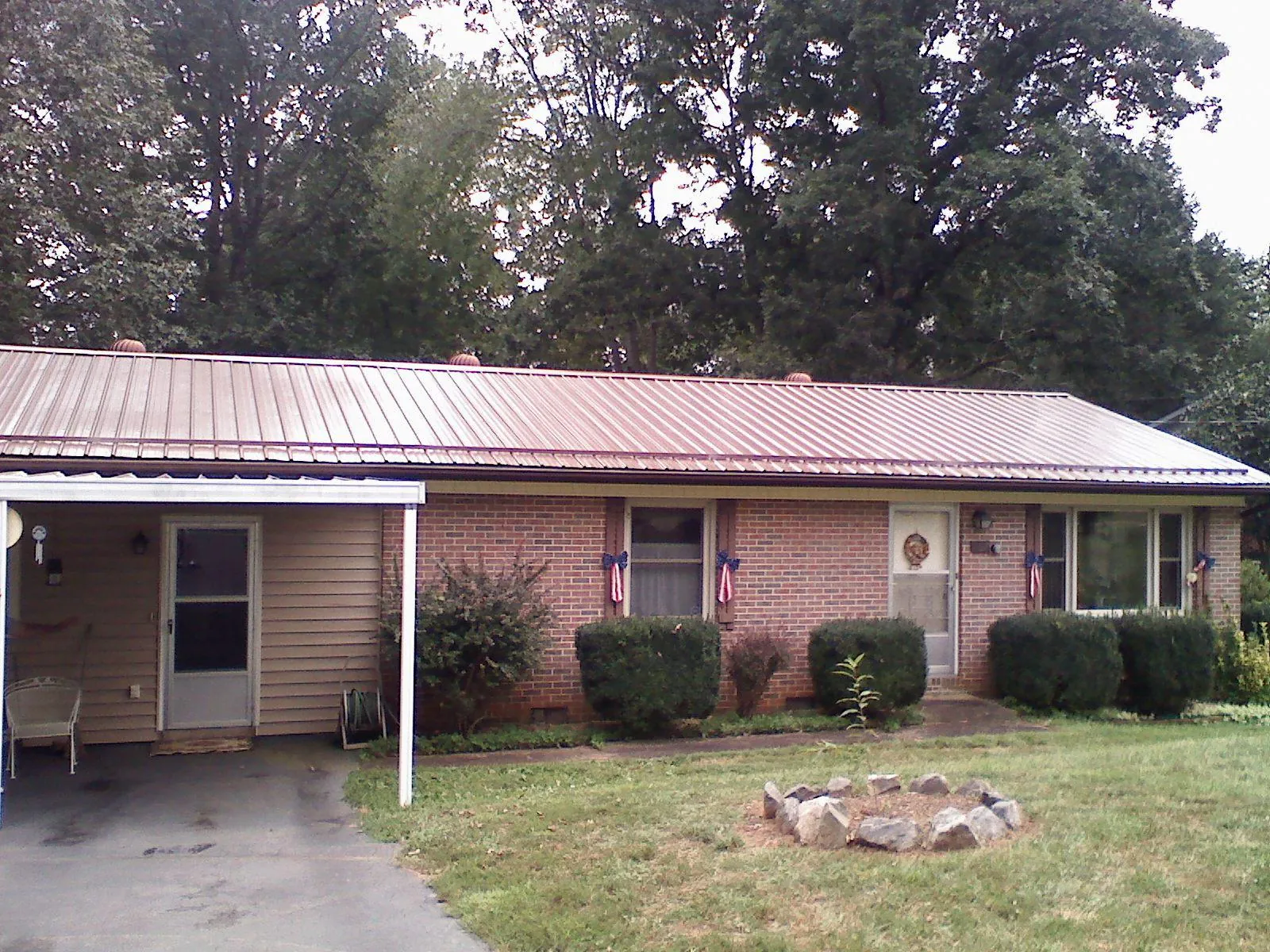 Bronze metal roof and carport on a brick ranch home — Roof Repair work by our crew in Polo